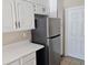 Kitchen features white cabinets and stainless steel refrigerator at 5835 W Amelia St, Orlando, FL 32835