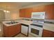 Kitchen with wood cabinets, white appliances, and tiled counters at 637 Lake Marion Golf Resort # 637, Kissimmee, FL 34759