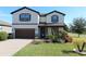 Two-story house with brown accents, paved driveway, and landscaping at 684 Bishop Bay Loop, Apopka, FL 32712