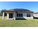 Home's back features a covered patio and solar panels at 684 Bishop Bay Loop, Apopka, FL 32712