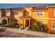Two-story townhome with orange exterior and landscaping at 8931 Bismarck Palm Rd, Kissimmee, FL 34747