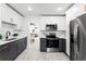 Modern kitchen with dark gray and white cabinets and stainless steel appliances at 1441 Dann St, Orlando, FL 32804