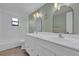 Bathroom with double vanity, arched mirrors, and light green walls at 2533 Edgewater Ave, New Smyrna Beach, FL 32168