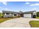 Gray house exterior with a red door, white garage door, and landscaping at 2533 Edgewater Ave, New Smyrna Beach, FL 32168