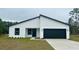 Modern single story home with white exterior and black garage door at 559 Marion Oaks Blvd, Ocala, FL 34473