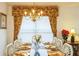 Well-lit dining room showcasing a formal dining setting and decorative window treatments at 8458 Secret Key Cove, Kissimmee, FL 34747