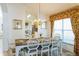 Elegant dining room with a dark wood table, white chairs, and a view into the kitchen at 8458 Secret Key Cove, Kissimmee, FL 34747