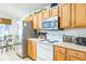 Bright kitchen boasts stainless steel appliances and wood cabinetry at 8458 Secret Key Cove, Kissimmee, FL 34747