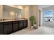 Bathroom with dark vanity, double sinks, and a large mirror at 1245 Limbali St, Mount Dora, FL 32757
