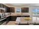 Modern kitchen with dark cabinets, granite countertops, and stainless steel appliances at 1245 Limbali St, Mount Dora, FL 32757