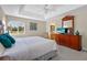 King-size bed, dresser with TV, ensuite bathroom at 128 Higher Combe Dr, Davenport, FL 33897