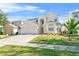 Two-story house with beige exterior, attached garage, and landscaping at 128 Higher Combe Dr, Davenport, FL 33897