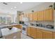 Bright kitchen with island, stainless steel appliances, and light wood cabinets at 128 Higher Combe Dr, Davenport, FL 33897