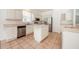 Kitchen with island, stainless steel appliances, and white cabinets at 1748 Golfview Dr, Kissimmee, FL 34746