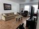 Living room with sofa, armchair, coffee table, and large TV at 2761 L B Mcleod Rd # C, Orlando, FL 32805