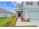 Two-story home's front entrance with walkway and landscaping at 3019 Tackle Dr, Leesburg, FL 34748
