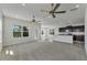 Open living room with kitchen, neutral carpet, and ceiling fans at 3019 Tackle Dr, Leesburg, FL 34748