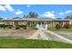 Front view of stone house with landscaping and driveway at 1018 E Lakeshore Blvd, Kissimmee, FL 34744