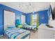 Fun ' bedroom with twin beds, blue walls, and Monsters Inc. decor at 1627 Kona Ln, Davenport, FL 33897