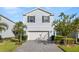 Two-story house with gray siding, white garage door, and landscaped front yard at 1627 Kona Ln, Davenport, FL 33897