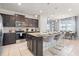 Modern kitchen with dark cabinets, granite island, and stainless steel appliances at 1627 Kona Ln, Davenport, FL 33897