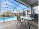 Screened patio with pool, table, and grill at 1627 Kona Ln, Davenport, FL 33897