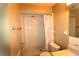 Clean bathroom featuring a shower stall with marble-like tiles and a seashell-themed shower curtain at 2214 Winnetka Ct, Orlando, FL 32818