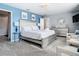 King-size bed, blue walls, and sitting area in bright bedroom at 4563 Narrative Ln, Kissimmee, FL 34746