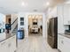 Open kitchen with stainless steel appliances and view into dining area at 4563 Narrative Ln, Kissimmee, FL 34746