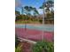 Community tennis court with red and green surface, behind chain-link fence at 348 Scottsdale Sq # 348, Winter Park, FL 32792