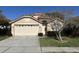 Two-story house featuring a tan exterior, double garage, and a tree at 5453 Shingle Creek Dr, Orlando, FL 32821