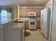 Kitchen with light wood cabinets, white appliances, and tile floor at 5453 Shingle Creek Dr, Orlando, FL 32821
