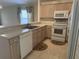 Kitchen boasts light wood cabinets, white appliances, and tile floors at 5453 Shingle Creek Dr, Orlando, FL 32821