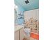 Bright teal bathroom with updated fixtures and a floral shower curtain at 6110 Curry Ford Rd # 219, Orlando, FL 32822