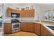 Kitchen with wood cabinets, stainless steel appliances, and granite countertops at 839 Franconville Ct, Kissimmee, FL 34759