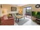 Living room with a green couch, red chair, and patio access at 2007 Disney Mgm Studio Ct, Kissimmee, FL 34746