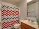 Simple bathroom with chevron shower curtain, wood vanity and mirror at 224 Fairfield Dr, Sanford, FL 32771