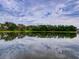 Serene lake view with tree-lined shoreline and cloud reflections at 224 Fairfield Dr, Sanford, FL 32771