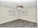 Spacious bedroom with ceiling fan, grey wood-look floors, and two windows at 5724 Se 2Nd St, Ocala, FL 34480