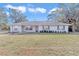 Ranch style home with red front door, well-manicured lawn and mature trees at 5724 Se 2Nd St, Ocala, FL 34480