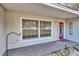 Front porch with red door and a window featuring a wooden framed door at 5724 Se 2Nd St, Ocala, FL 34480