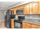 Kitchen boasts granite countertops, oak cabinets, and black appliances at 5724 Se 2Nd St, Ocala, FL 34480