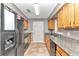 Kitchen featuring granite countertops, oak cabinets, and black appliances at 5724 Se 2Nd St, Ocala, FL 34480