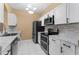 Modern kitchen featuring stainless steel appliances and white cabinets at 580 Brantley Terrace Way # 203, Altamonte Springs, FL 32714