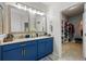 Double vanity bathroom with blue cabinets and a walk-in closet at 637 Bay Bridge Cir, Apopka, FL 32703