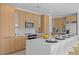 Modern kitchen with light wood cabinets, quartz countertops, and island seating at 6491 Octave St, Mascotte, FL 34753