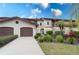 Two-car garage, attractive landscaping, and a Spanish-style facade at 104 Coventry Ln, Haines City, FL 33844
