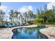 Freeform pool and spa with ample lounge chairs and lake view at 11103 Bridge House Rd, Windermere, FL 34786