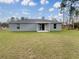 House exterior with covered patio and grassy backyard at 13055 Sw 67Th Ave, Ocala, FL 34473