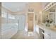 Large bathroom with double vanity, soaking tub, and a separate shower at 24946 Cranes Roost Circle, Leesburg, FL 34748